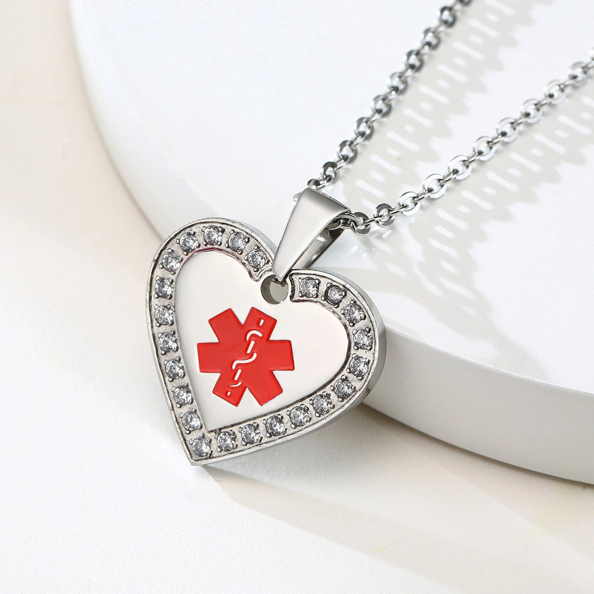 Silver cubic zirconia heart medical alert pendant, angled close-up